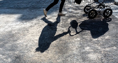 Schatten einer Frau mit Kinderwagen